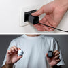 Supertiny 65W - Compact black 65W charger plugged into white wall outlet with hand holding Charger, and person in white shirt holding charger in comparison to a golf ball. - Rolling Square